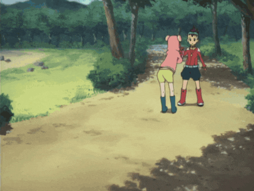 a boy and a girl standing on a dirt path in the woods
