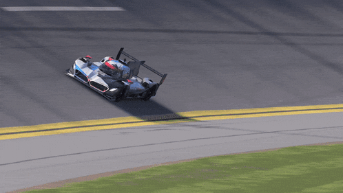 a race car is going around a curve with a yellow line on the side