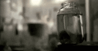 a jar filled with water is sitting on a table .