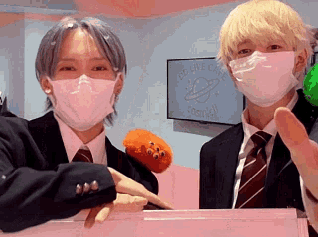two people wearing face masks in front of a sign that says od live cafe foamell