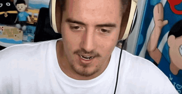 a man wearing headphones and a white shirt is smiling .