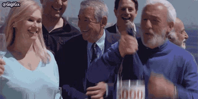 a group of people are posing for a picture and one man is holding a bottle that says 1000 on it