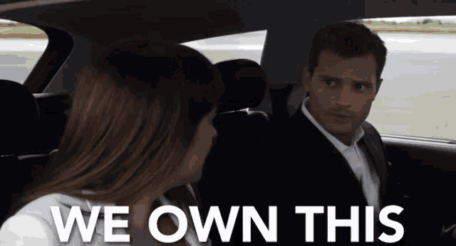 a man and woman in a car with the words we own this