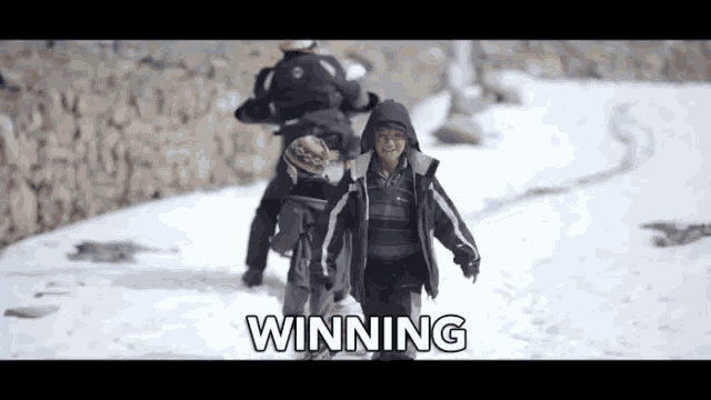 a group of children are walking in the snow and the word winning is on the screen