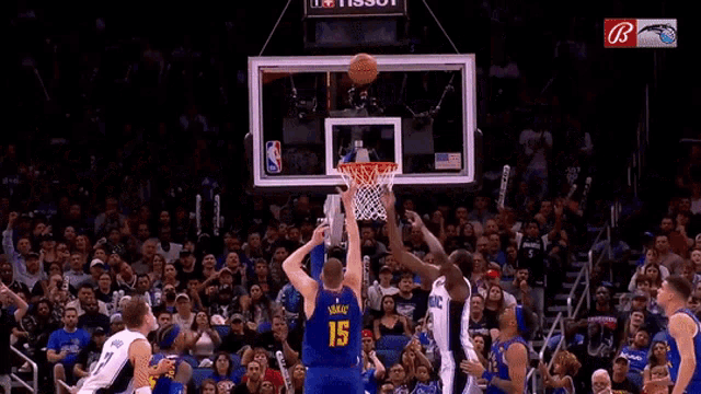 a basketball player wearing a number 19 jersey tries to block a shot from another player