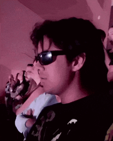 a man wearing sunglasses is sitting in a row of people