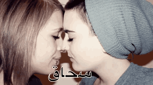 a couple of women kissing with arabic writing on the bottom