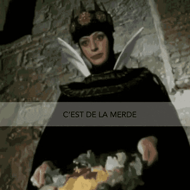 a woman in a witch costume is holding a bouquet of flowers in her hands .