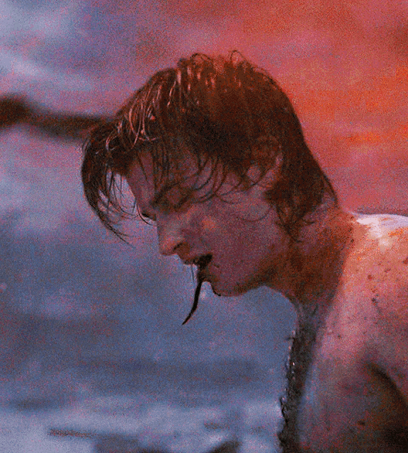a man with blood coming out of his mouth is looking down