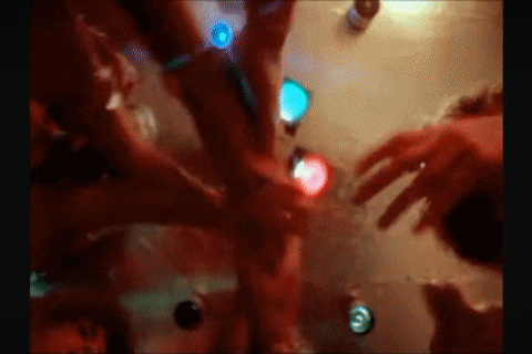 a blurry picture of a group of people dancing in a dark room with lights .