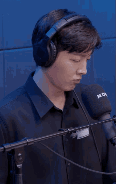 a man wearing headphones and a shirt that says now