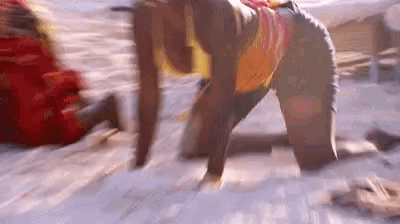 a blurry picture of a woman kneeling down on the beach