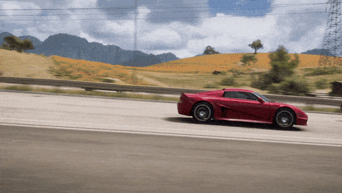 a red sports car is driving down a road