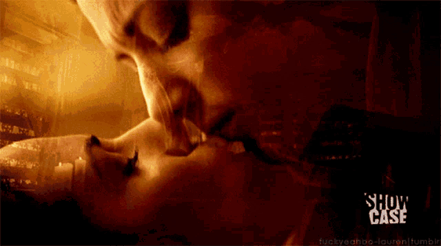 a man and woman kissing in front of a display case