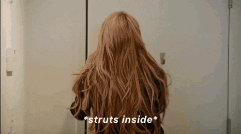 a woman with long hair is standing in front of a door and the words struts inside