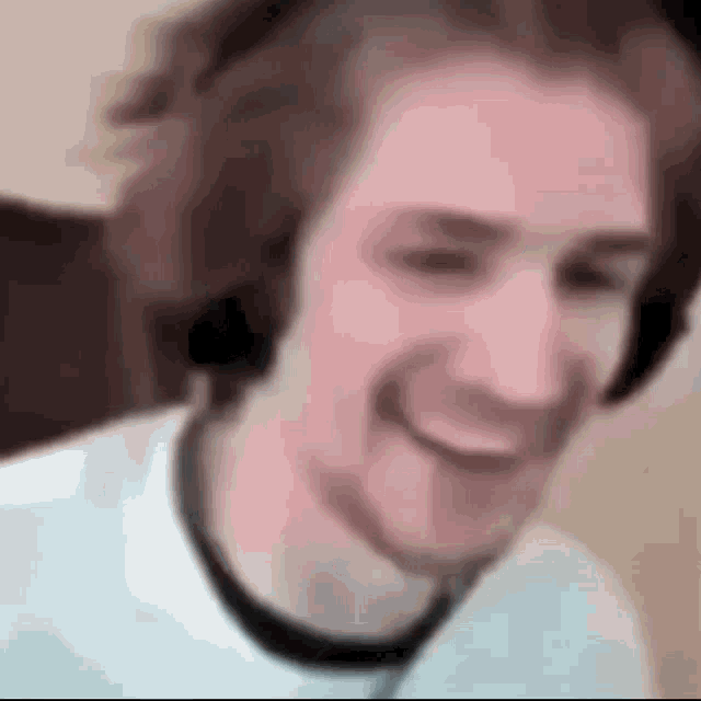 a man wearing headphones is smiling in a blurry photo .