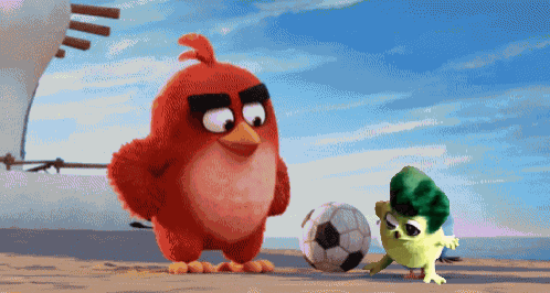 two angry birds are playing with a soccer ball on a beach