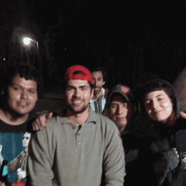 a group of people posing for a picture with one wearing a hat that says ' abercrombie & fitch ' on it