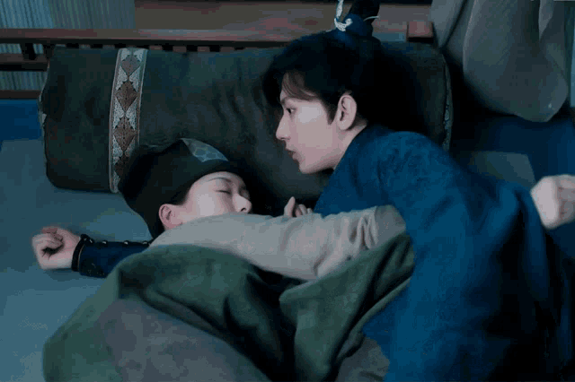 a man and a woman are laying on a bed and the man is looking at the woman