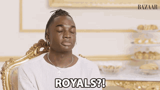 a man sitting in a chair with the words royals written on his face