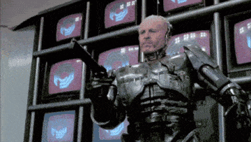a man in a robotic suit is holding a gun in front of a wall of televisions