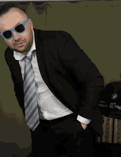 a man in a suit and tie is wearing a pair of sunglasses