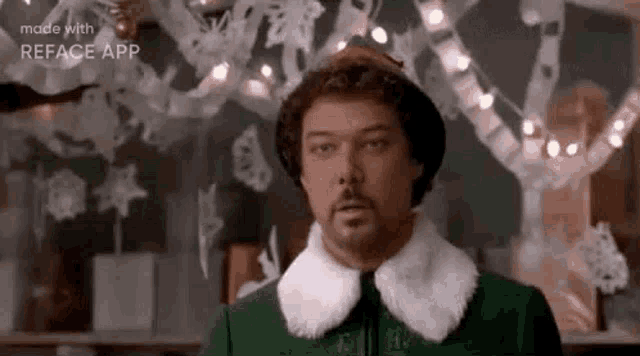 a man in a green suit and white collar is standing in front of a chalkboard with snowflakes on it .