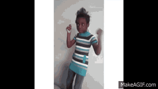 a young girl in a striped shirt is dancing on make a gif.com
