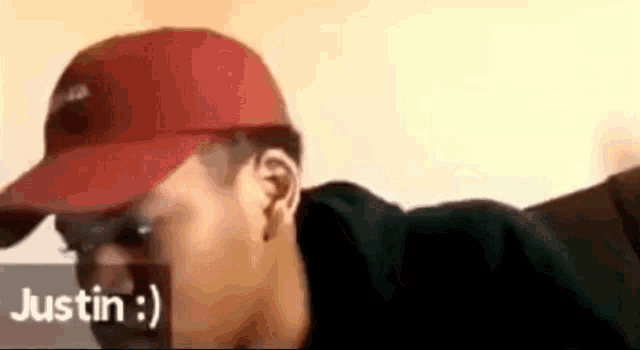 a man wearing a red hat and sunglasses is talking to another man .