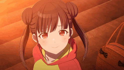 a girl with pigtails and a red hoodie smiles for the camera