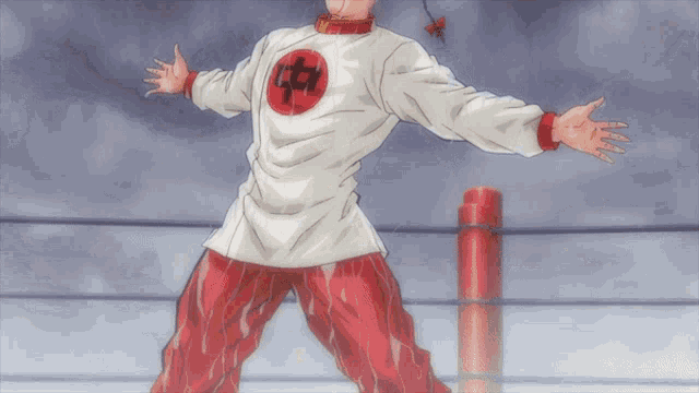 a man with his arms outstretched is wearing a white shirt with a red circle with the letter h on it