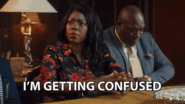 a man and a woman are sitting at a table and the woman says i 'm getting confused