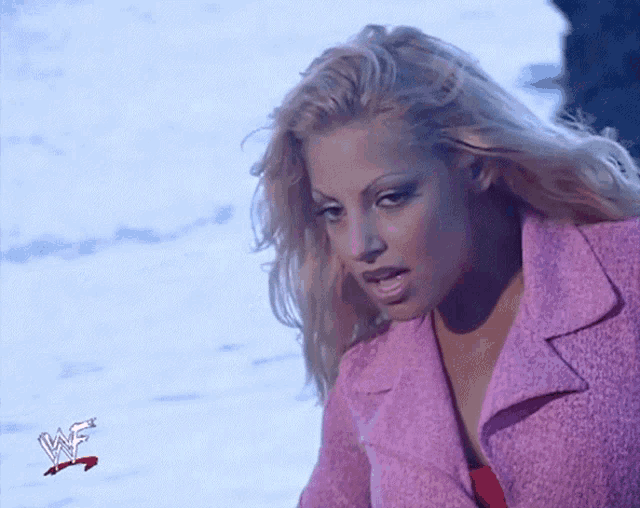 a woman is wearing a pink jacket with a wrestlemania logo on it