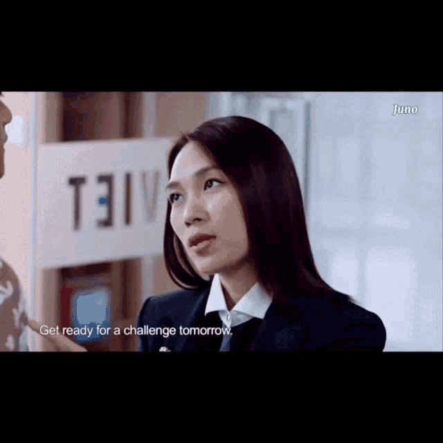 a woman in a suit is talking to a man in front of a sign that says t3iv