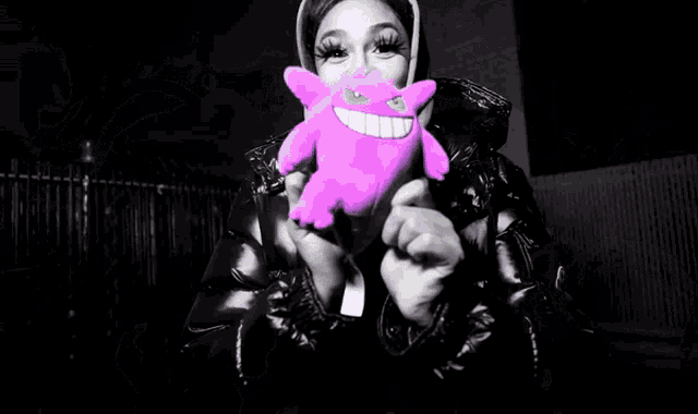 a person holding a pink stuffed animal with a big smile on it