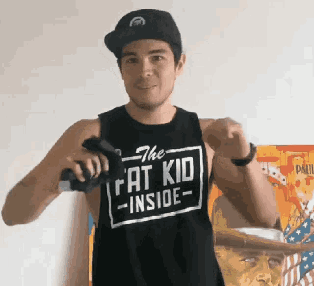 a man wearing a tank top that says " the fat kid inside "