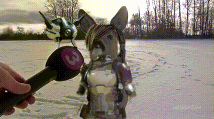 a person is holding a microphone in front of a stuffed animal in a snowy field .