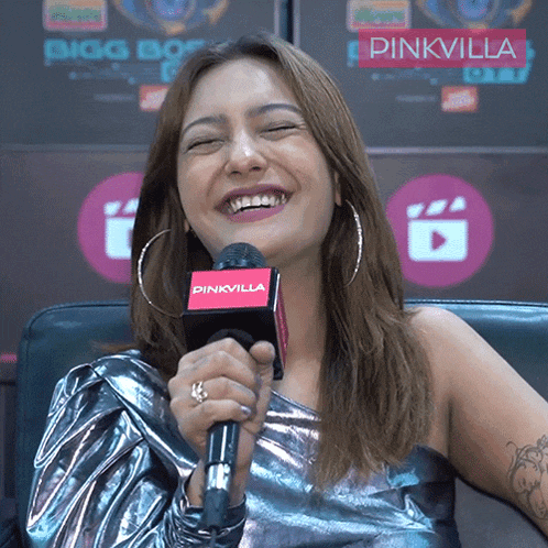 a woman is smiling while holding a microphone that says pinkvilla on it
