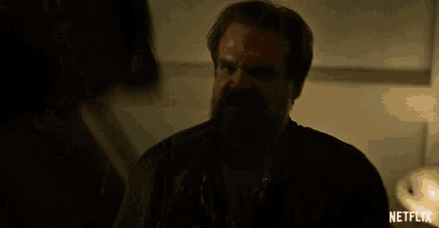 a blurred image of a man in a dark room with a netflix logo in the corner