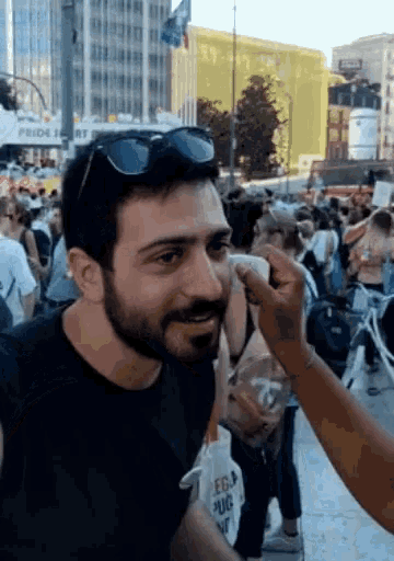 a man with a beard is being touched by a woman with a bag that says egg on it
