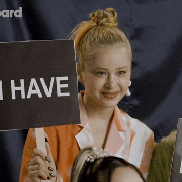 a woman holds up a sign that says i have