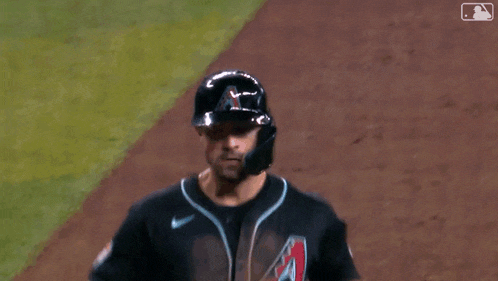 a baseball player wearing a helmet and gloves is being congratulated by another player .