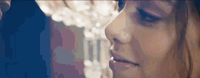a close up of a woman 's face with a man 's hand on her nose .