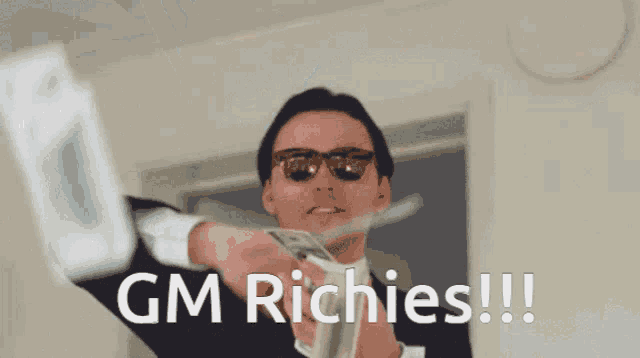 a man in a suit and sunglasses holds a bunch of money and says gm richies !!!