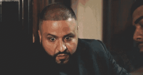 a man with a beard is making a funny face while looking at the camera .