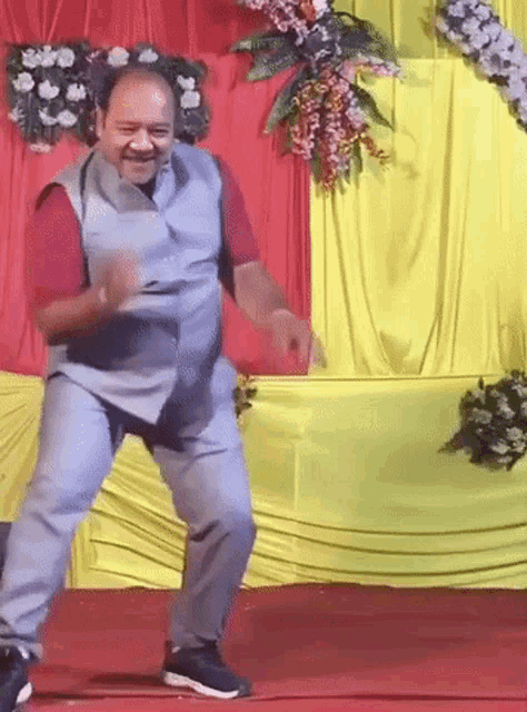 a man is dancing on a stage in front of a yellow and red curtain