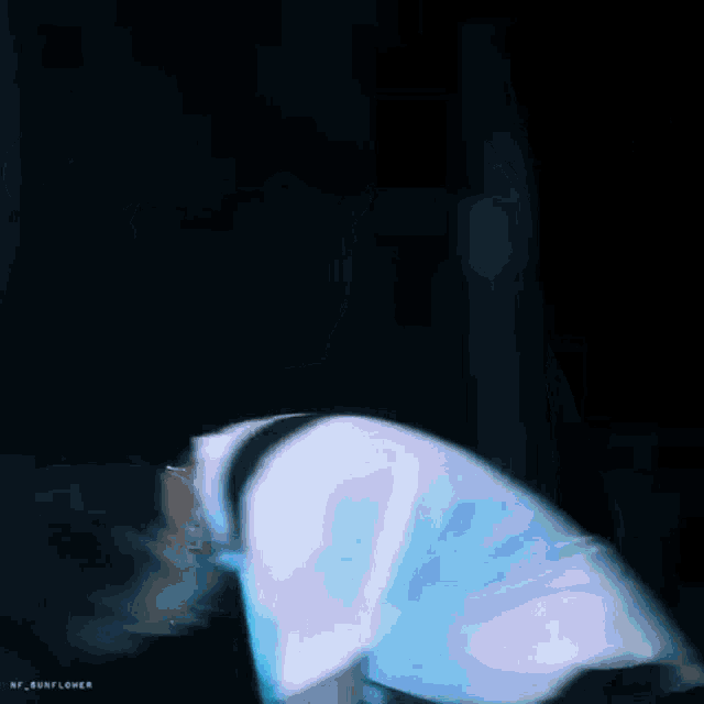 a man in a blue shirt is holding another man 's arm in the dark .