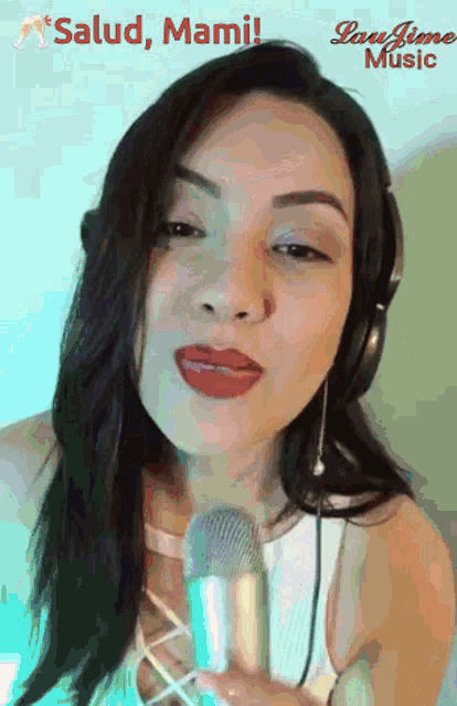 a woman wearing headphones is singing into a microphone with the words salud mami written above her