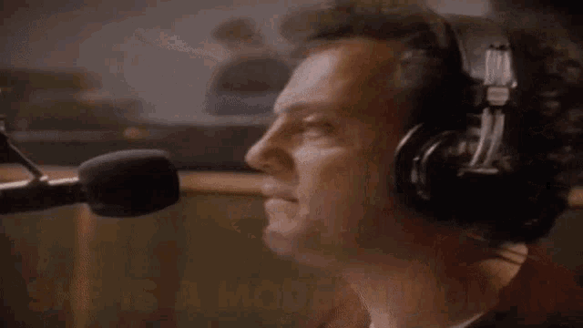 a man singing into a microphone with the words " she is a modern woman " above him