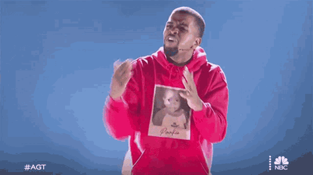 a man in a red hoodie has a picture of a baby on his sweatshirt